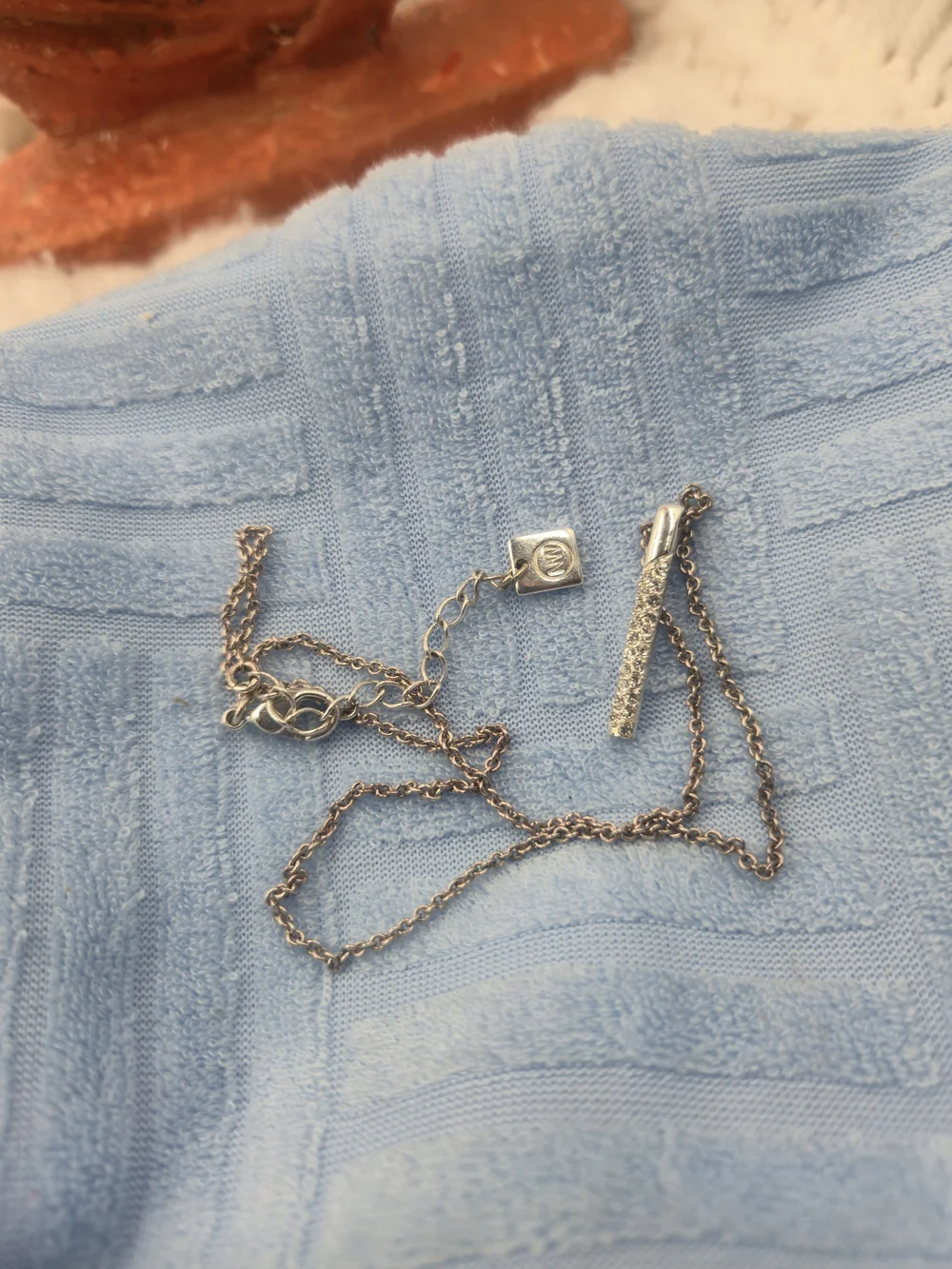 Nine West necklace features a dainty bar pendant adorned with pavé stones